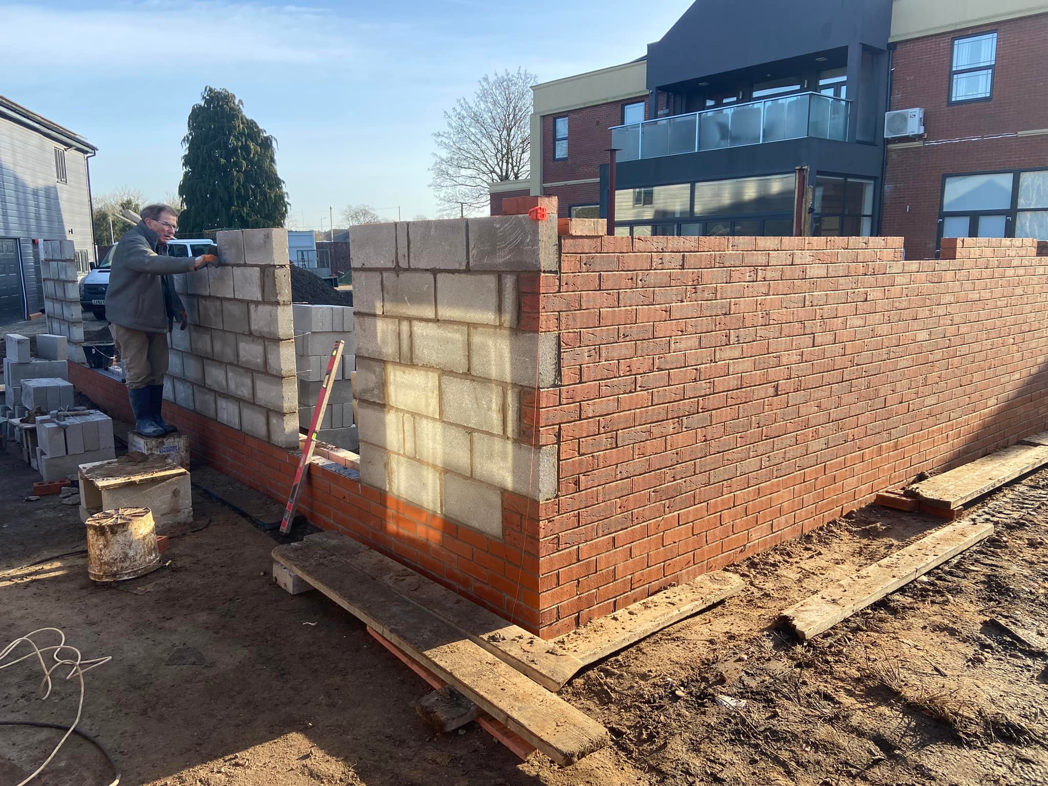 Worker building brick and concrete block walls on a construction site
